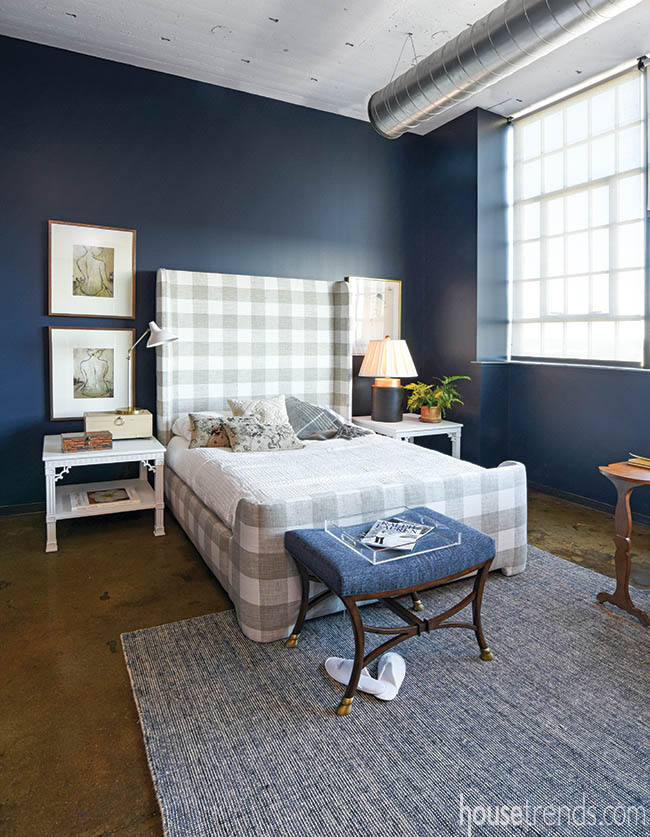 Patterned headboard complements navy walls