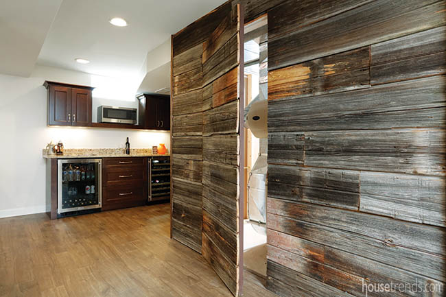 Wall of reclaimed wood masks a door