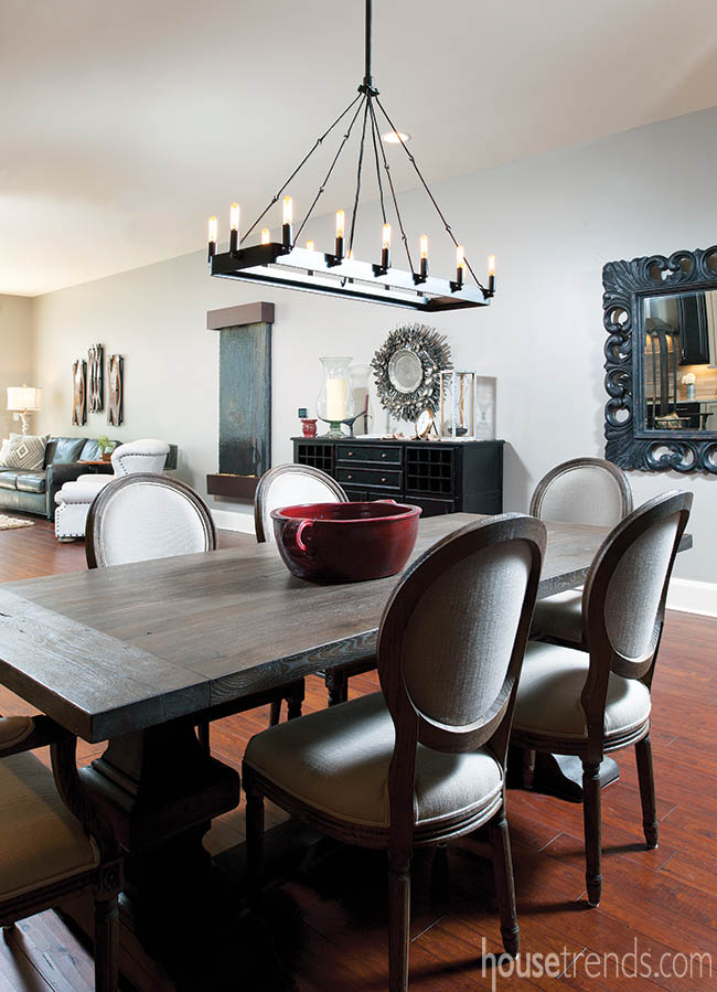 Metal chandelier dangles over a reclaimed dining table