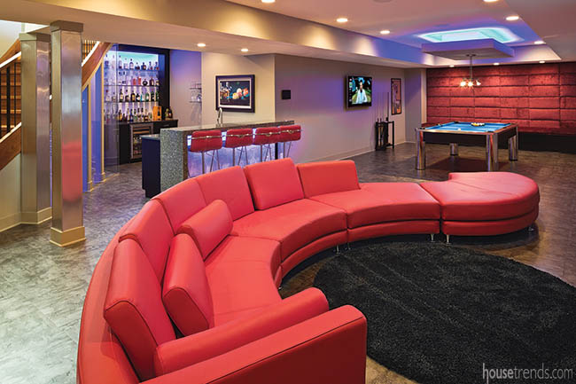 Red leather couch dominates a basement