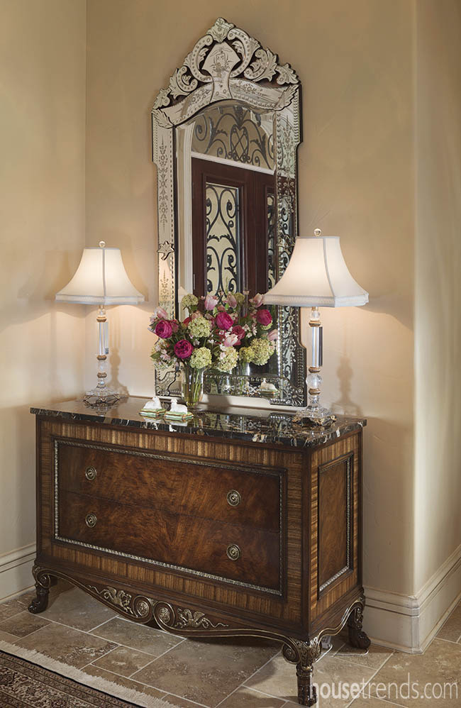 Venetian mirror reflects an elegant foyer