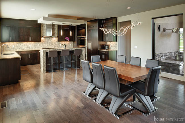 Curvy light fixture dangles over a dining table