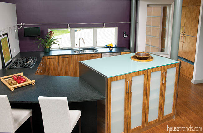 Glass countertops and zebra cabinetry contribute to a stunning kitchen