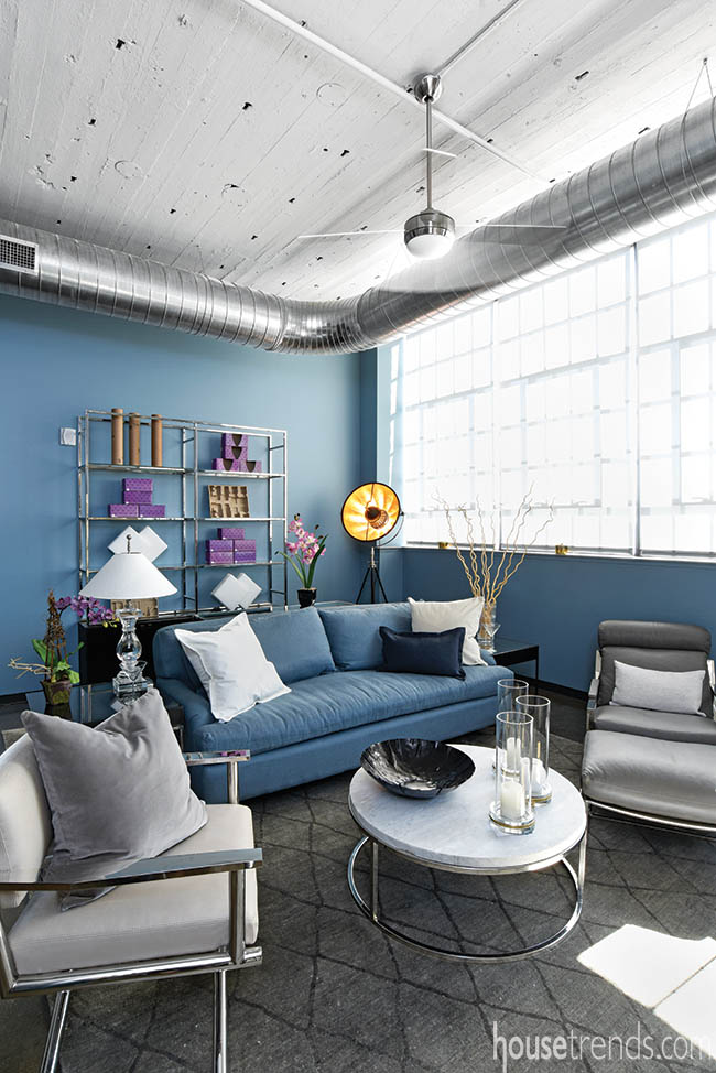 Purple accessories pop against a blue living room