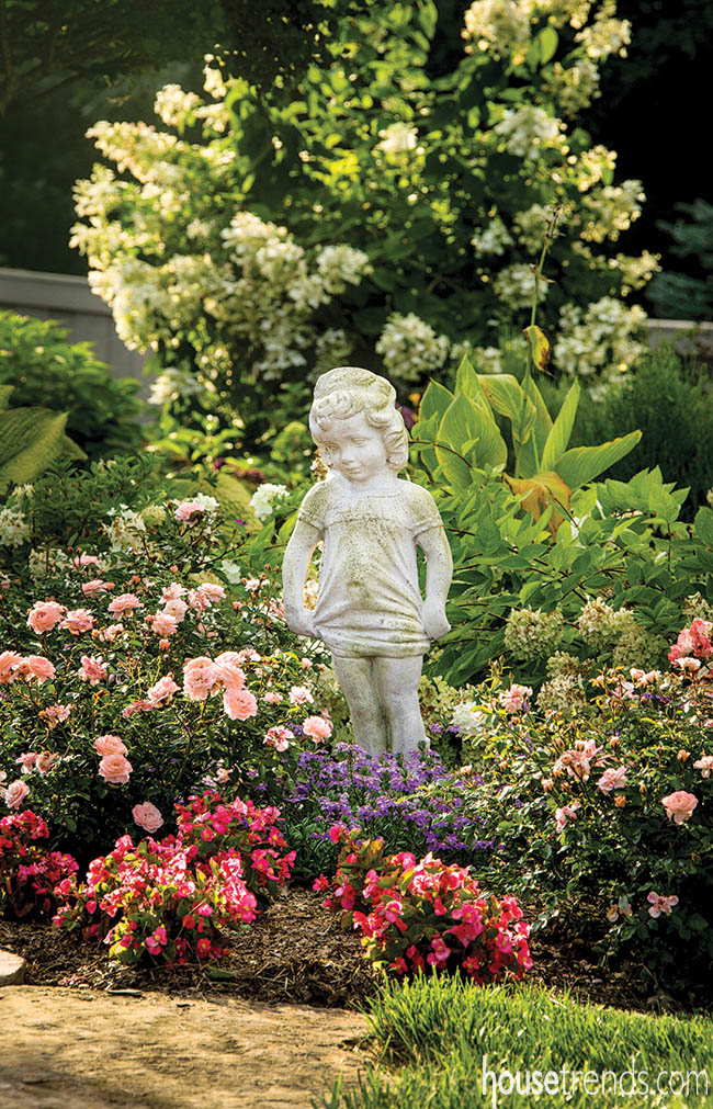 Flowers and statue add interest to a back yard