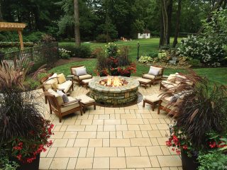 Cushioned chairs surround a gas fire pit