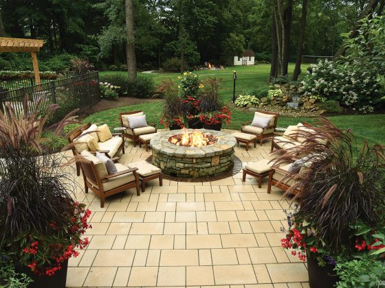 Cushioned chairs surround a gas fire pit