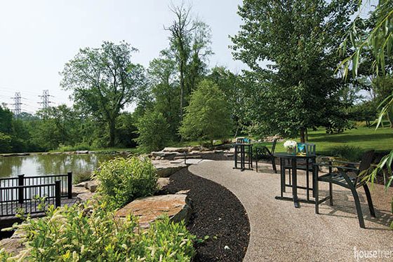 Seating areas overlook a pond in a spacious back yard