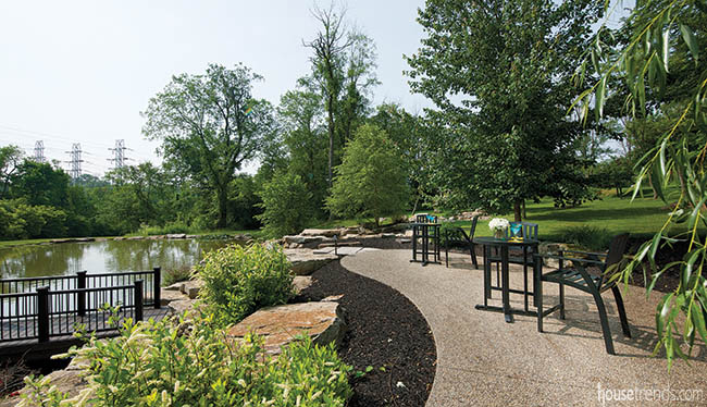 Seating areas overlook a pond in a spacious back yard