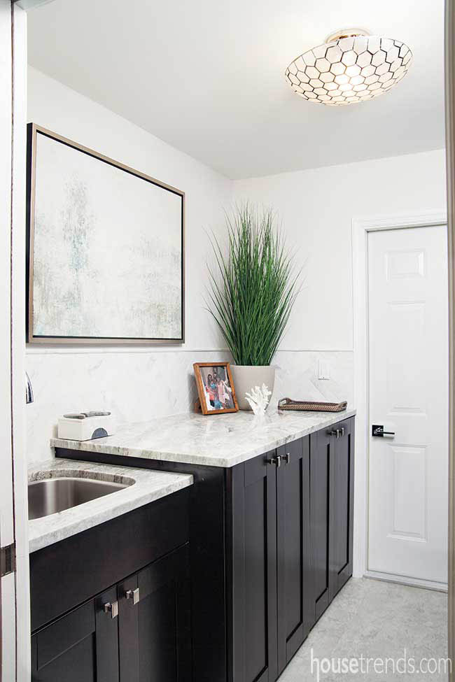 Dark cabinetry hides a washer and dryer