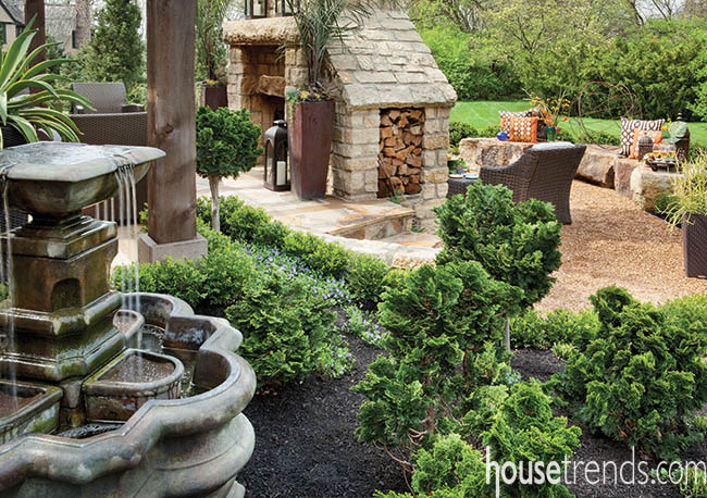 Lush landscaping surrounds an outdoor water fountain