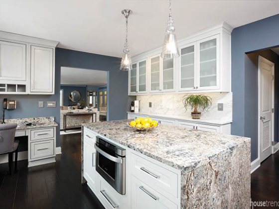Pendant lights shine on a large kitchen island