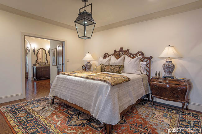 Colorful area rug pops in a neutral master bedtoom