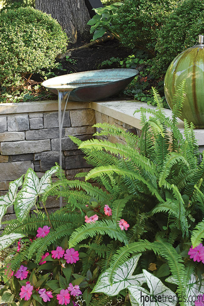 Water feature tops off a retaining wall