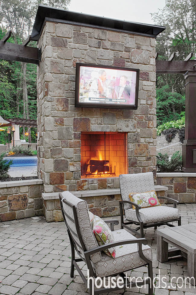 Outdoor fireplace lights up a patio design