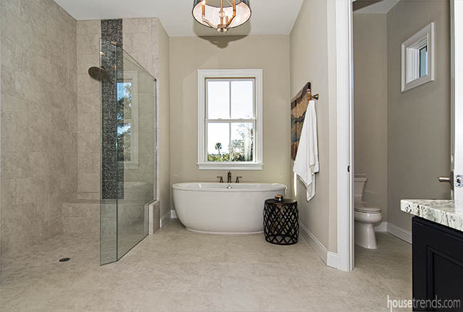 Glass wall creates illusion of privacy in a master bathroom