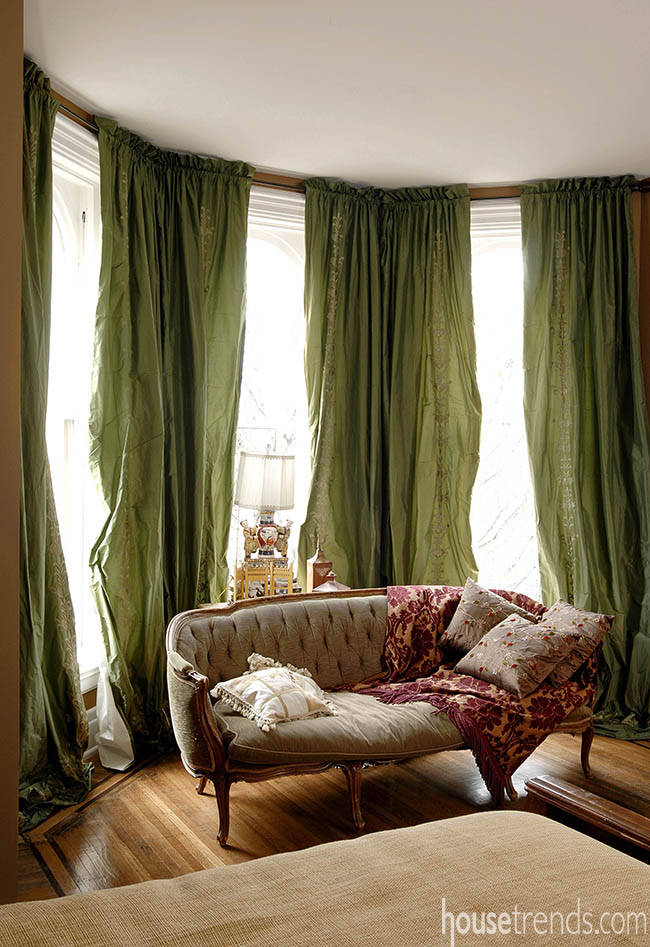 Green drapes color up a bedroom sitting area