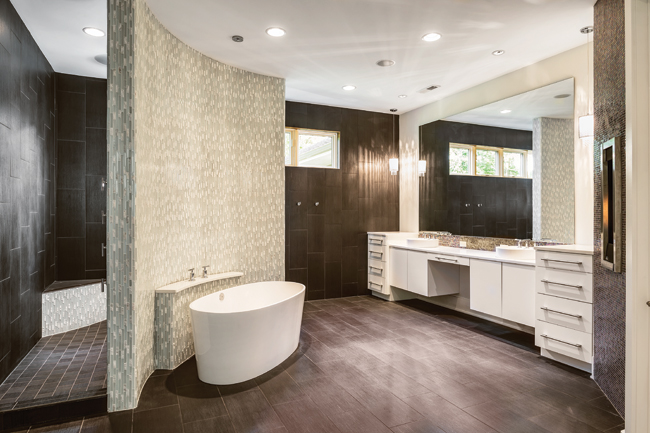 Glass tile wall adds privacy between the bathtub and shower areas
