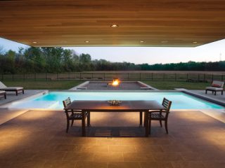 A minimalistic patio is covered by a cantilevered roof