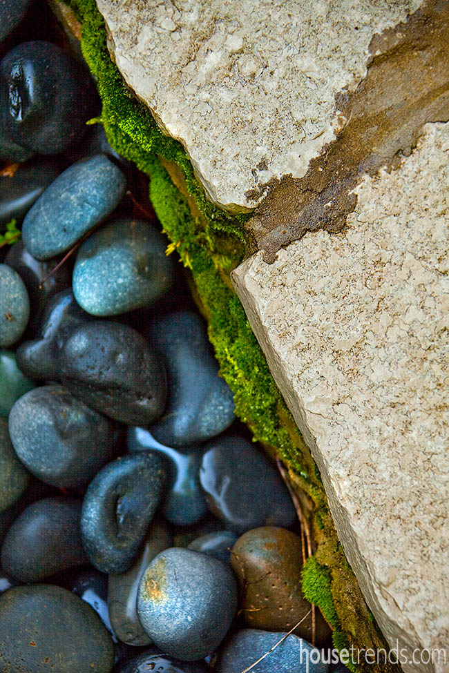 Dark beach rocks create a border in a garden