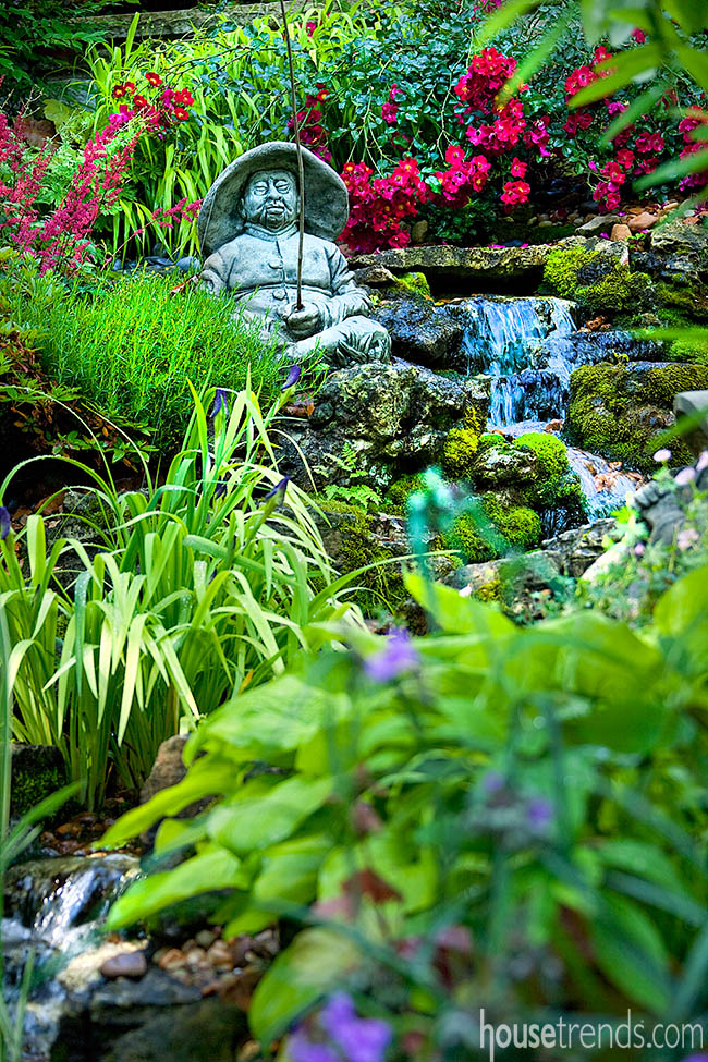 Garden statue sits amongst flowers
