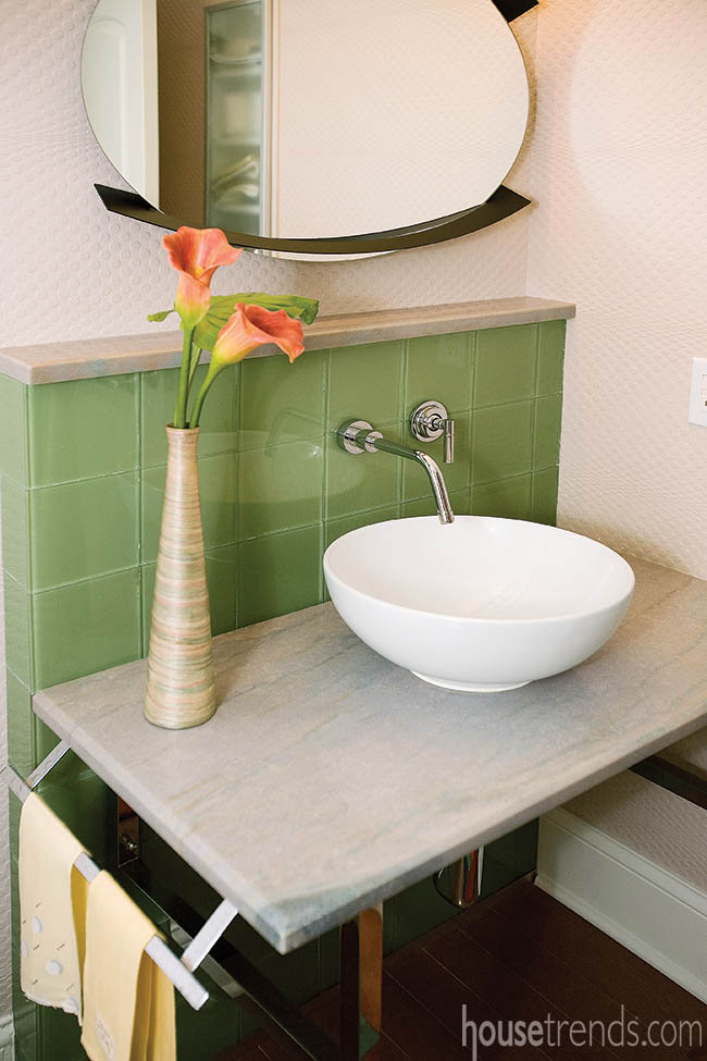 Vessel sink pops against green tile