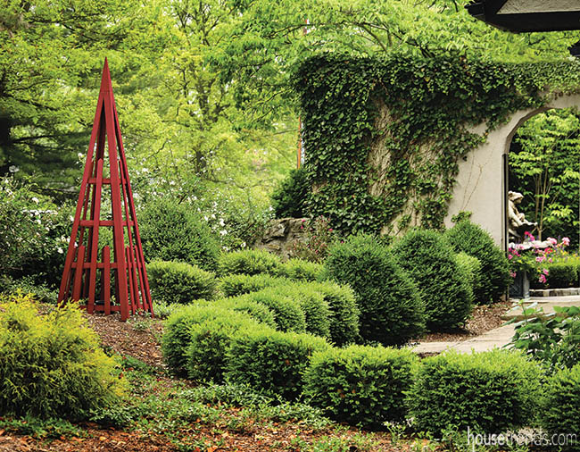 Garden gate connects a lush landscape and nearby courtyard