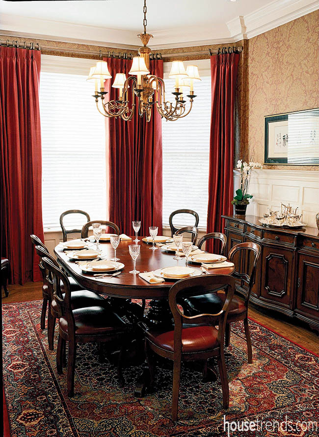 Red curtains lend elegance to a formal dining room