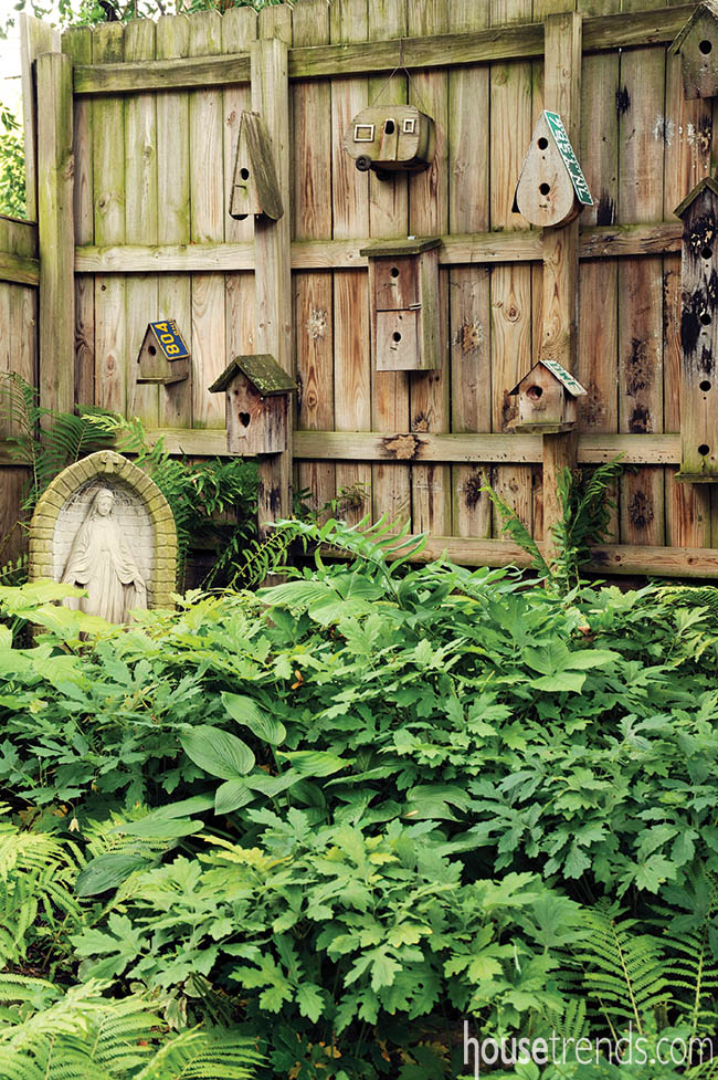 Bird houses decorate a privacy fence