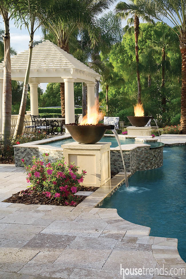 Fire bowls around a swimming pool double as water features
