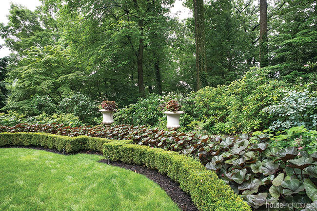 Layers of plants add dimension to an oval garden